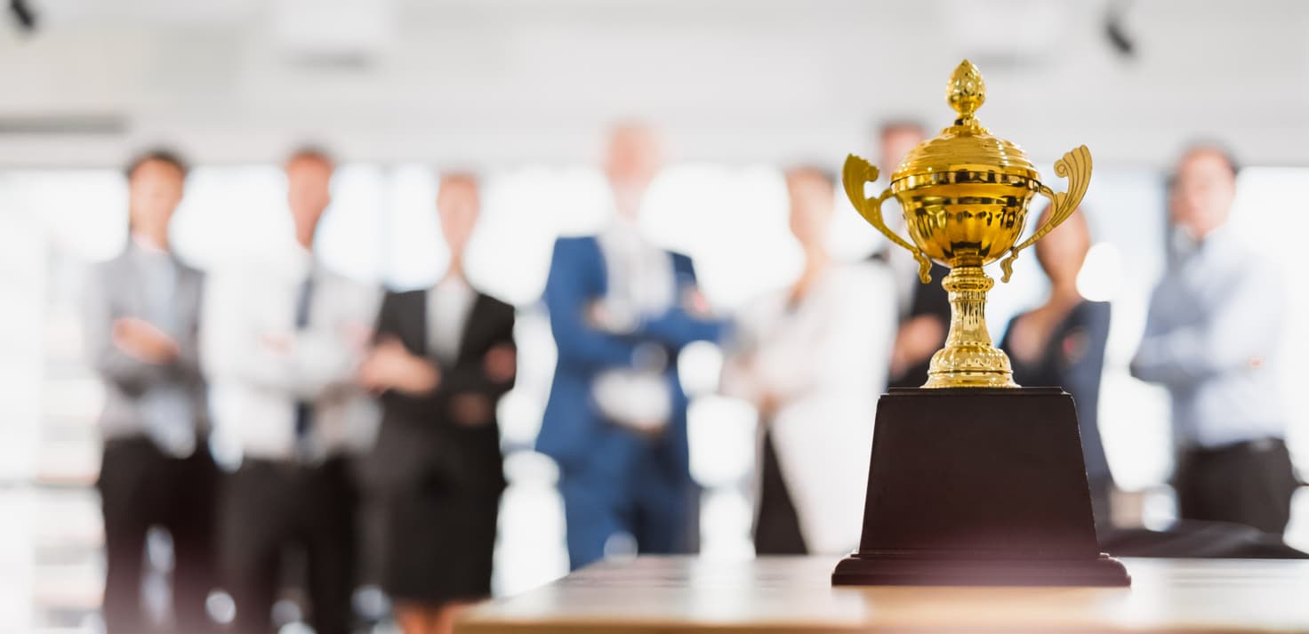 Employees admiring a trophy received in recognition of their service