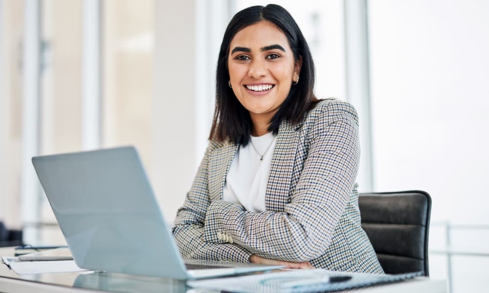 A smiling employee sitting in their office.