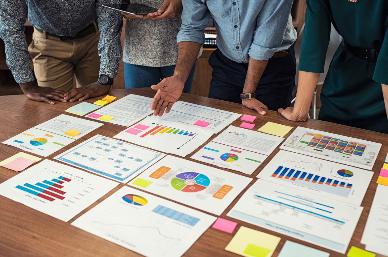 team members looking at colorful documentation metrics on a table