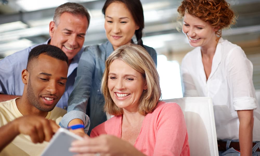 A group of coworkers check the standings of an employee engagement challenge thanks to gamification