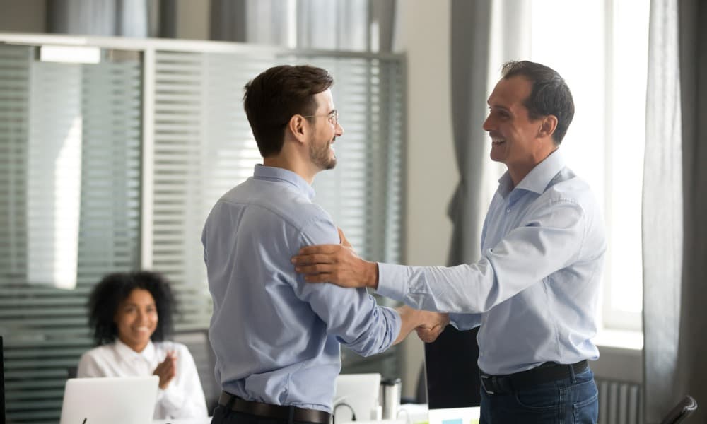 A manager shaking an employee’s hand and expressing appreciation for his good work.