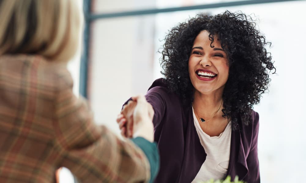 Two women shaking hands.