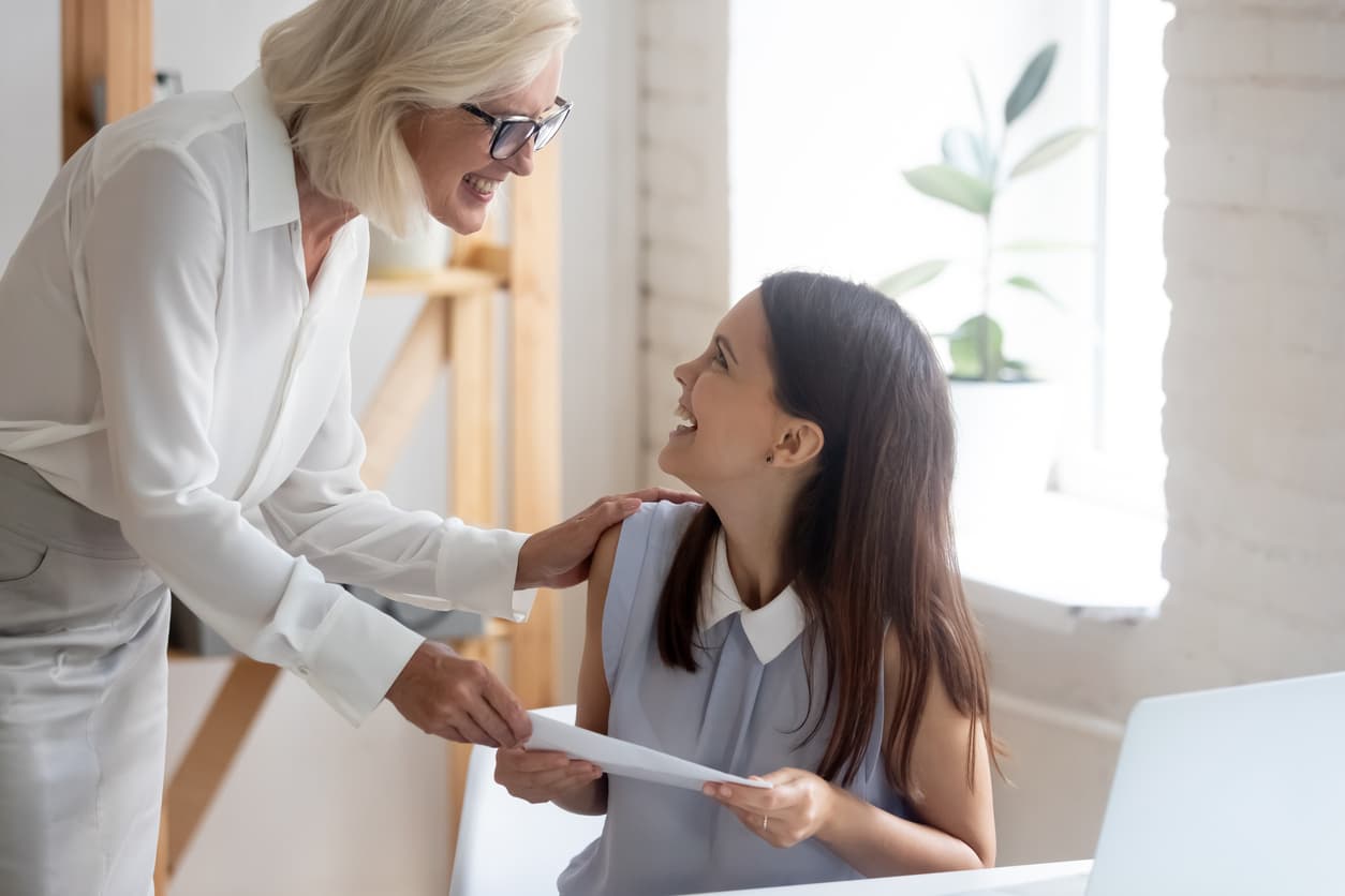 A woman giving an employee a reward as part of an employee recognition program 