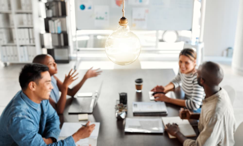 Business people sit around a conference table exploring current tech trends that help MSPs see growth