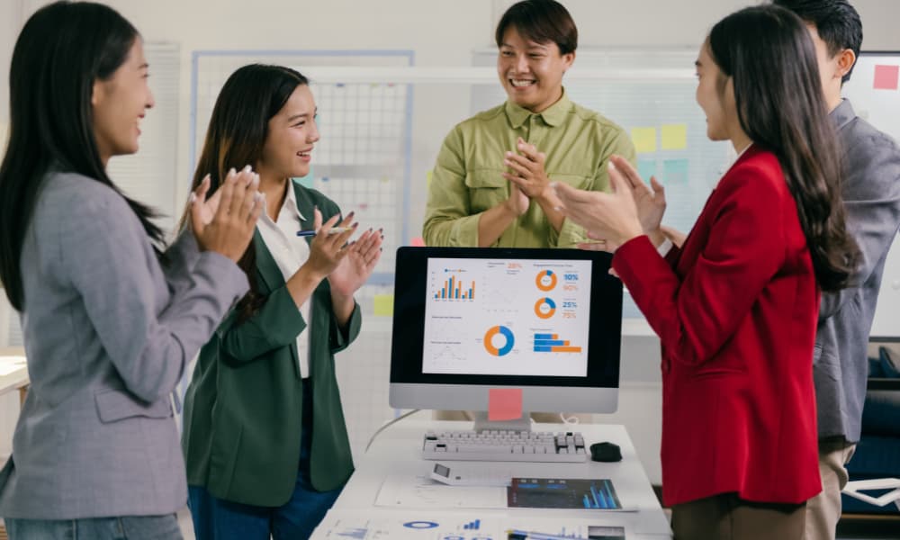 A group of employees clapping for a top-performing employee